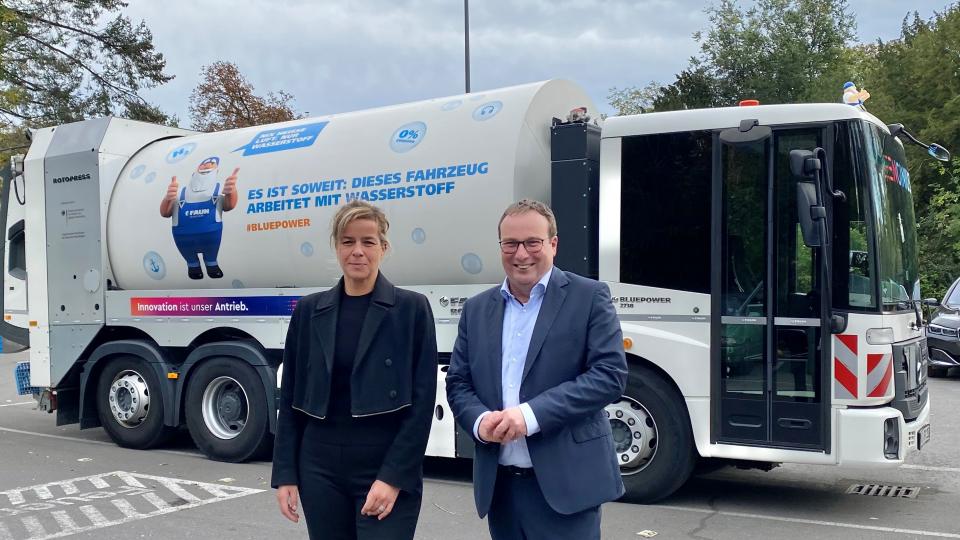 Ministerin Neubaur beim Kompetenztreffen Klimagerechte Mobilität NRW vor einem mit Wasserstoff betriebenen Müllfahrzeug